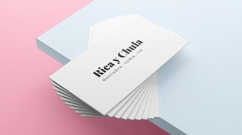 Cristina Lain Una pila de tarjetas de presentación con la marca "Ricay Chula" y la frase "descubre. come. rie" reposa elegantemente sobre un fondo azul claro y rosa. Branding Fotografía Mentorias